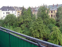 Blick von einem Balkon auf den gr&uuml;nen Innenhof